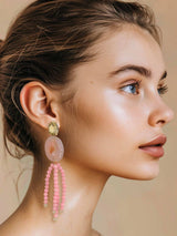 Model wearing Mata Roze Agaat statement oorbellen with pink agate stone and dangling crystal beads.