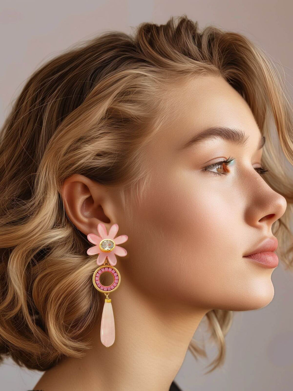 Vrouw met roze statement oorbel met agaat, messing en kristallen details, van het Maud Roze sieradenassortiment