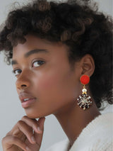 Model wearing Mavi orange shell earrings with pearl and gold details, showcasing elegant and luxurious design.