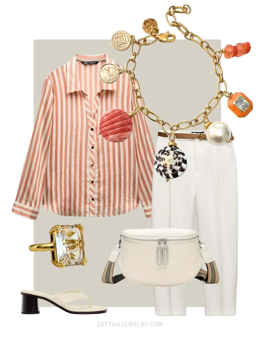 Stylish outfit with a striped blouse, white pants, and accessories including a gold charm bracelet with orange beads, a ring, and a white handbag.